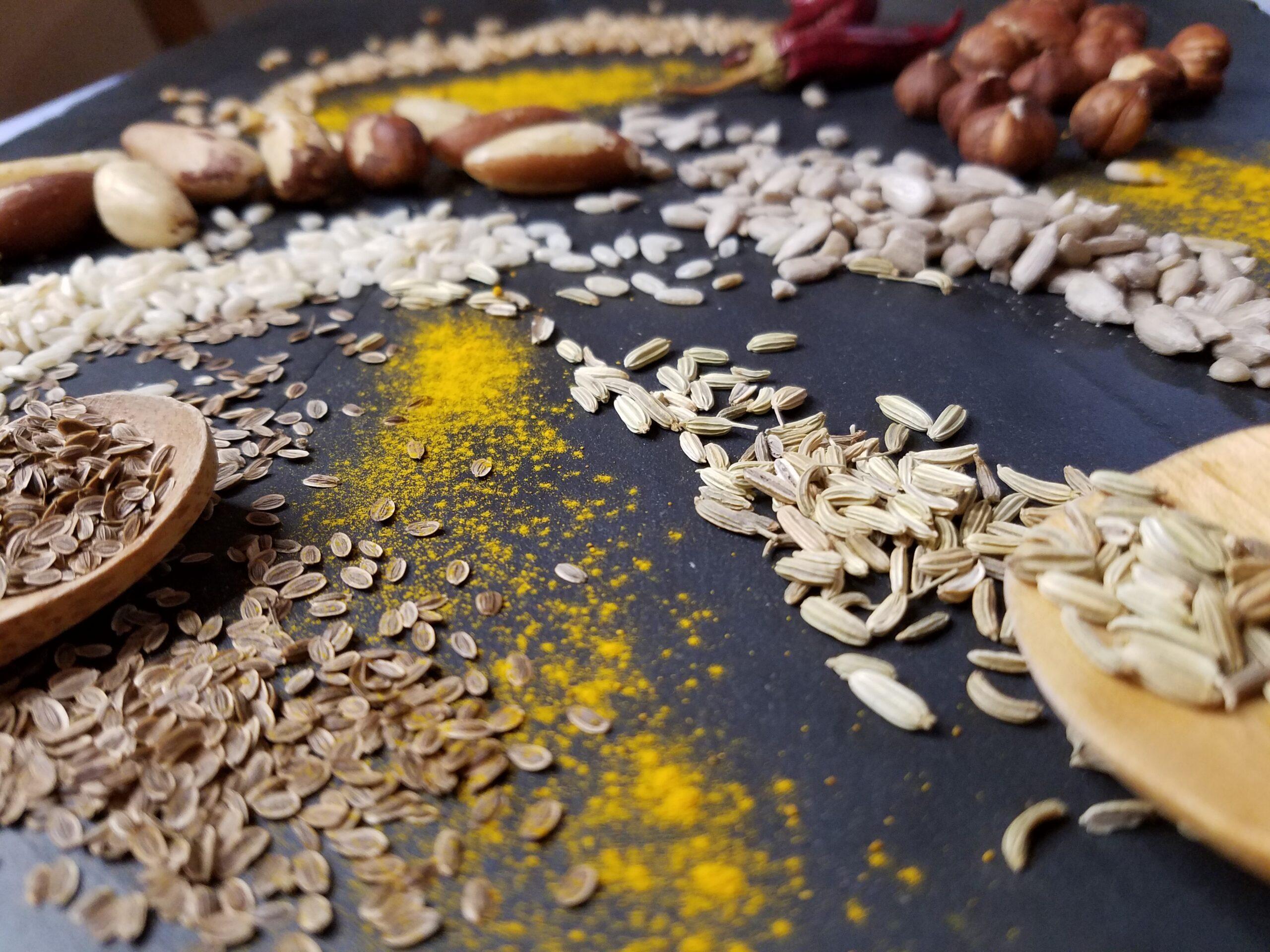 Photo en gros plan de graines et d'épices de différentes couleurs sur une ardoise